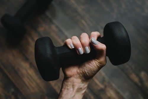 a hand holding a bar bell weight