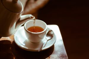 Pouring tea into a cup from a teapot