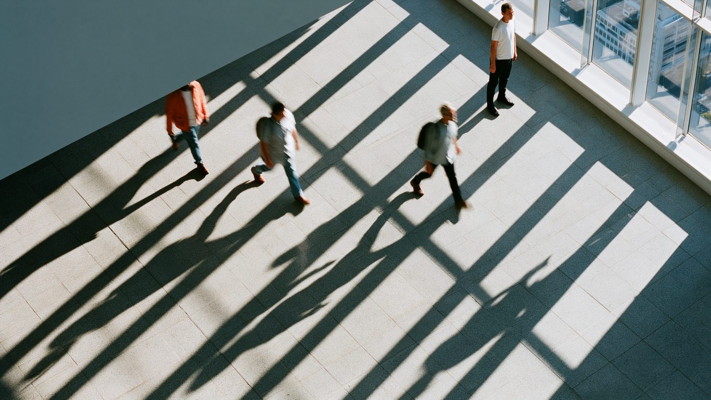 People walking through a bright modern building, symbolizing the different paths individuals take toward alcohol moderation management and healthier drinking habits.